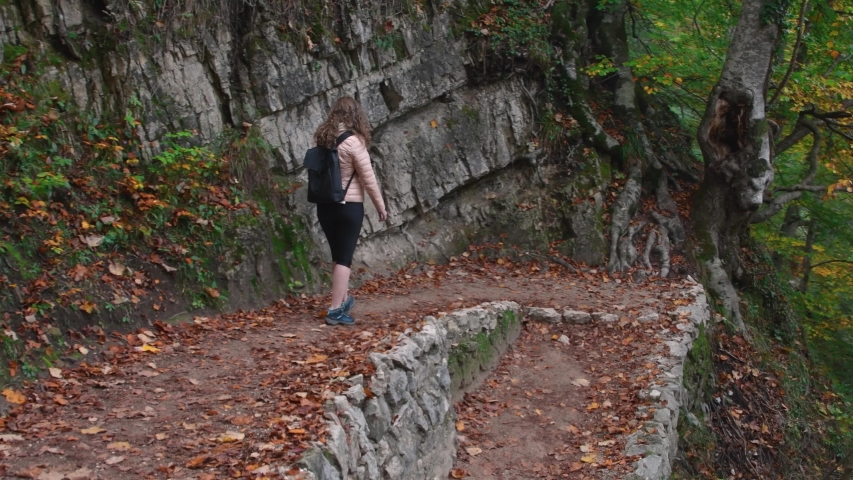 Autumn Plitvice Lakes, National Park in Croatia, UNESCO world heritage. Woman trekking on wooden trail