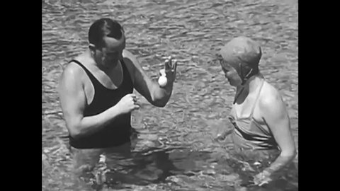CIRCA 1930s - A beginning swimmer learns about her buoyancy, picking an egg up off the seafloor, during a swimming lesson, in 1938.