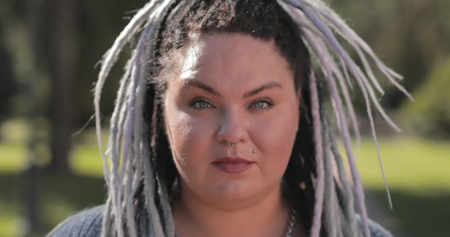 Portrait of happy smiling especially interesting woman with piercings with dreadloks. Pretty fat or stout girl showing body positive attitude to herself. Royalty-Free Stock Footage #1056881780