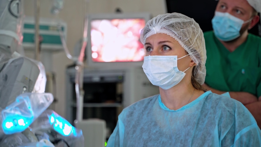Robotic arms for minimally invasive surgery. Female surgeon perform a delicate operation using medical surgical robot. Modern medicine in hospital. Royalty-Free Stock Footage #1056882938