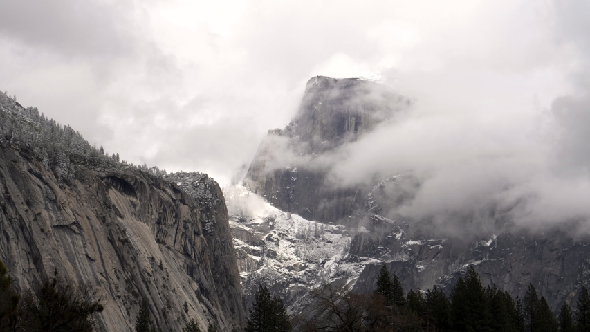 half dome covered in snow and mist during a winter storm at yosemite national park in california, usa
