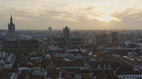 Ghent Belgium Aerial  Flying backwards over town with full downtown church cityscape views at sunset - November 2019