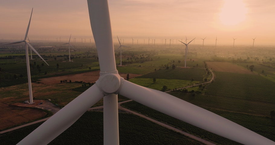 Aerial view of Wind turbines Energy Production- 4k aerial shot on sunset. 4k drone footage turbines at sunrise with clouds | Shutterstock HD Video #1056894797