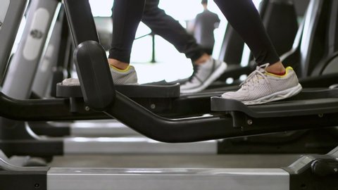 Group of healthy people exercising on the elliptical machine in the indoor gym or fitness room. Healthcare and wellness in active people from everyday workout.