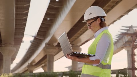 Woman foreman working on construction site using laptop computer.