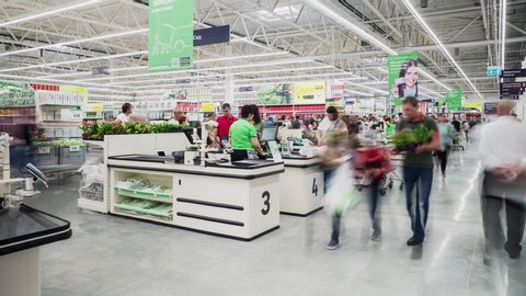 KAZAN, TATARSTAN/RUSSIA - MAY 11 2020: Numerous different customers with purchases walk along cashier desks in modern spacious supermarket timelapse on May 11 in Kazan