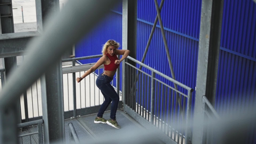 Slow motion shot of dancing blond woman on staircase | Shutterstock HD Video #1056900980