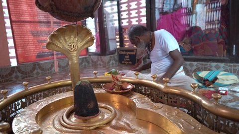 AMRAVATI, MAHARASHTRA, INDIA 10 JUNE 2020 : Hindu priest perform puja or prayer to Shiva linga in the oldest Shiva Temple in the region of Maharashtra, India.