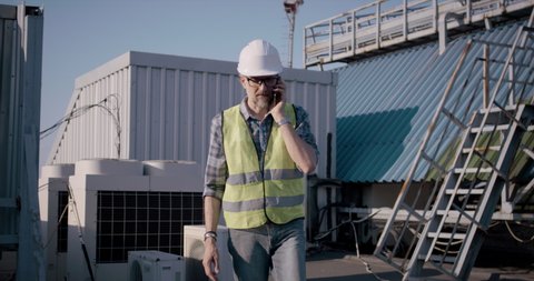 Tracking shot of an engineer having a phone call while walking