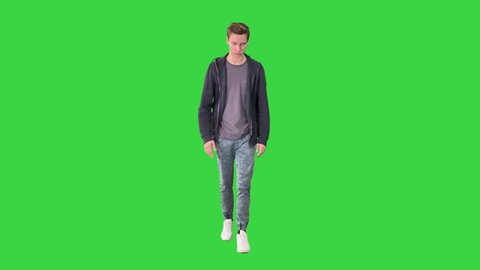 Young attractive student walking forward on a Green Screen, Chroma Key.
