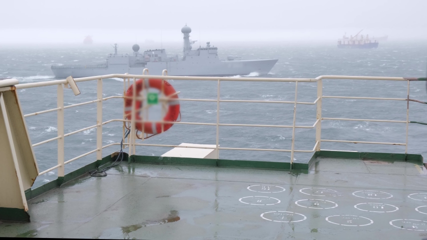 large white warship astern Natig Aliev tanker during heavy storm on Danish port of Skagen raid against grey waving sea