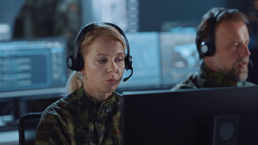 Military Surveillance Team of Officers with Headsets Working in a Central Office Hub for Cyber Operations, Control and Monitoring for Managing National Security, Technology and Army Communications. Royalty-Free Stock Footage #1056907676