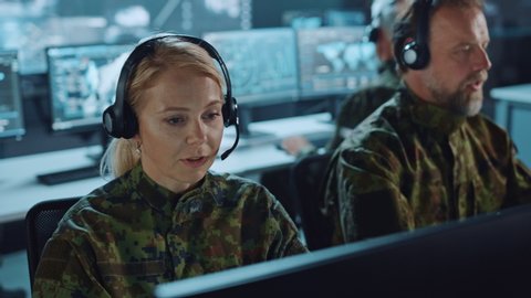 Military Surveillance Team of Officers in Headsets Working in a Central Office Hub for Cyber Operations, Control and Monitoring for Managing National Security, Technology and Army Communications.