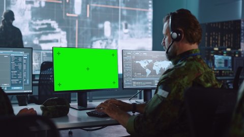 Military Surveillance Officer Working on Computer with Green Screen in Central Office for Cyber Operations, Control and Monitoring for Managing National Security, Technology and Army Communications.