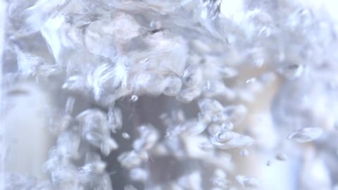 Close up view of boiling water boiling water in a transparent dish or in a glass teapot or saucepan, boiling water strong bubbling liquid.