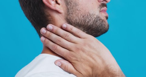 Neck pain, muscle stress and strain. Stressed man massaging neck, close up profile view
