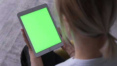 Woman With A Tablet Pc In Hands With A Green Screen, Chroma Key.