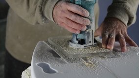 Shaper working on a surfboard using mask shaping and cleaning the board nose. The clip is part of a collection of several clips about surfboard making. Surfing apparel and equipment production.