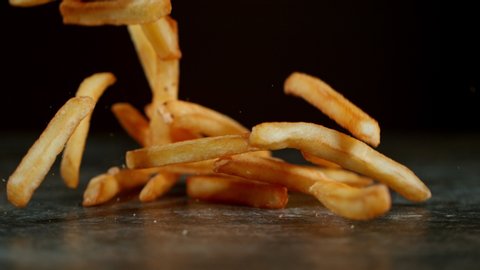 Super Slow Motion Shot of Falling Fresh French Fries on Stone Table and at 1000fps.
