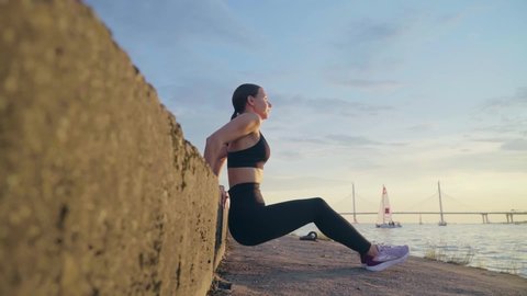 Woman Athlete  doing triceps dip exercise outdoors. Slow motion of fitness workout in urban city background. Active and sport concept. Urban background Stock Video
