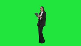 Side view of young business woman working on tablet using interactive touch screen. Full length on green screen background - Powered by Shutterstock - Get 15% off with code: PIKWIZARD15