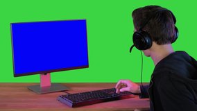 Gamer talking about the game on the screen to camera on a Green Screen, Chroma Key.