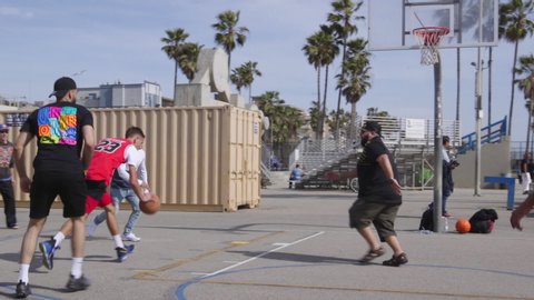 Los Angeles , California / United States - 04 06 2018: An unknown man in a Michael Jordan jersey scoring a layup on the basketball courts at Venice Beach in Los Angeles, California.