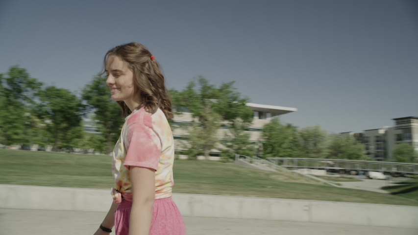 Slow motion tracking shot of girl looking at camera while roller skating / Salt Lake City, Utah, United States