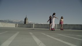 Distant carefree girls roller skating on top level of parking garage / Salt Lake City, Utah, United States