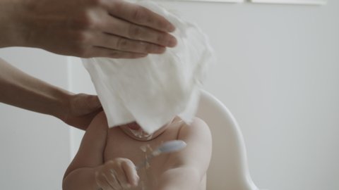 Slow motion close up of woman wiping face and hands of messy baby boy / Cedar Hills, Utah, United States