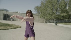 Slow motion tracking shot of girl looking at camera while roller skating / Salt Lake City, Utah, United States