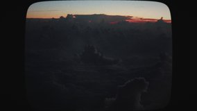 Airplane view of lightning strikes in the clouds at sunset. Stormy sky with lightning flashing and thunder. Evening thunderstorm clouds. Vintage Film Look.