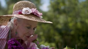 Stop to smell the flowers. Enjoying retirement in a beautiful garden. Tranquility and peaceful woman smells the flowers and enjoys life. shot in 4k.   - Powered by Shutterstock - Get 15% off with code: PIKWIZARD15
