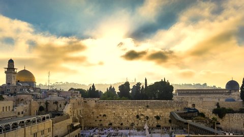 Beautiful time lapse of sunrise clouds moving fast over the Temple Mount: Dome of the Rock, Western Wall and Al Aqsa Mosque; with Jewish people praying in sections because of covid-19 regulations 