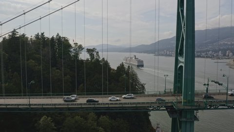 Vancouver BC Canada Aerial Bridge and traffic detail moving away from park with inlet and cruise ship in backdrop - August 2019
