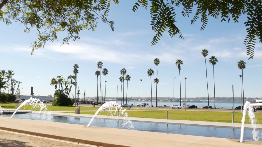 Fountain in waterfront city park near San Diego county civic center in downtown, California government authority, USA. Pacific ocean harbour, embarcadero in Gaslamp Quarter. Palms and grass near pier.