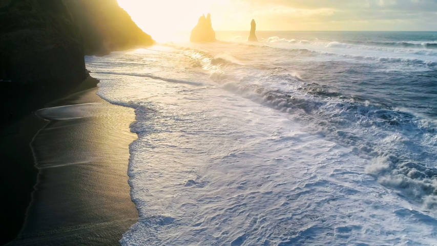 Huge waves crashing and splashing on a Black Beach in Iceland. Aerial view of Atlantic ocean on sunrise | Shutterstock HD Video #1056977759