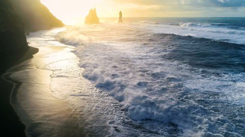 Huge waves crashing and splashing on a Black Beach in Iceland. Aerial view of Atlantic ocean on sunrise