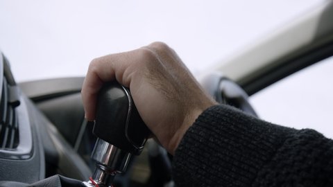 Male hand changes gear pulling gearstick down and indicates in delivery van, slow motion.
