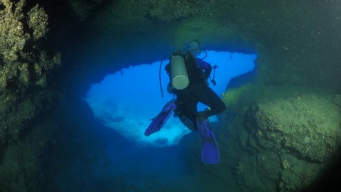 happy cave diving underwater scuba divers exploring caves ocean scenery sun beams and rays background