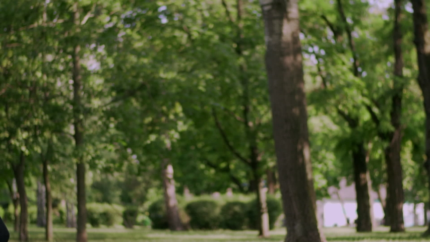 Young woman gymnast jumping in twine on in the park, slow motion.
