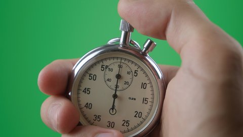 Male hand holding analogue stopwatch on green screen chroma key. Time start with old chronometer man presses start button in the sport concept. Time management concept.