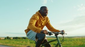 Smiling african american man in cycling on road in the countryside bicycle happy bike biking portrait active raised relax ride sunshine slow motion - Powered by Shutterstock - Get 15% off with code: PIKWIZARD15