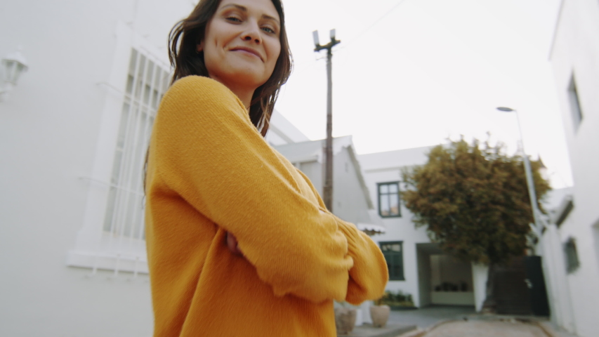 Zoom-in shot of a beautiful woman standing on the street puckering and walking away. Pretty woman wearing trendy casual clothing on the road.
 Royalty-Free Stock Footage #1056988907