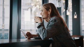 Woman sitting at a coffee shop with mobile phone drinking coffee and looking away. Caucasian female relaxing at a cafe.
 - Powered by Shutterstock - Get 15% off with code: PIKWIZARD15