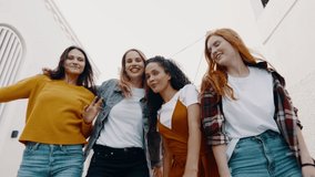 Group of beautiful four women friends dancing together outdoors. Diverse group of women enjoying dancing on the street.
