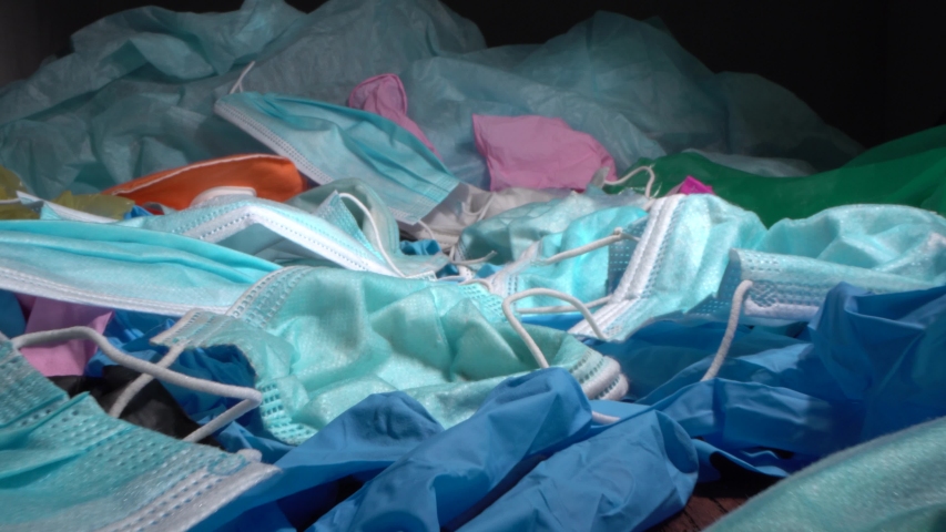 COVID-19 Waste Pollution crisis. Used discarded disposable face masks and latex gloves that have ended up in oceans, in a landfill during the pandemic Royalty-Free Stock Footage #1056998306