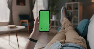 Close up shot of person relaxing on sofa and using smart phone with mock up green screen, doing various gestures - technology, communication 4k video template