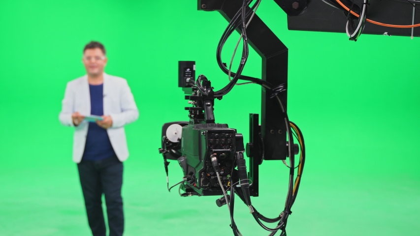 Film crew in green studio shooting video. Chroma - technology of combining two or more images or frames in single composition. Cameraman, director, crew. Filmmaking industry. | Shutterstock HD Video #1057003157