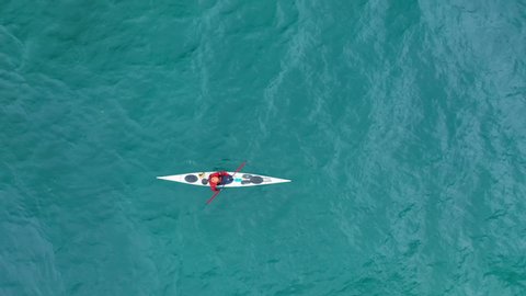 Still 4K aerial view of extreme kayaking sport in open green waters of Pacific ocean. People exercising in outdoor by sailing in kayak canoe. Active outdoor lifestyle and adventure travel on sunny day Stockvideó
